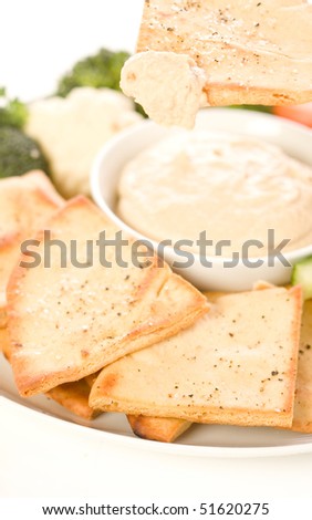 Pita chips and fresh vegetable make a healthy appetizer or snack along with hummus