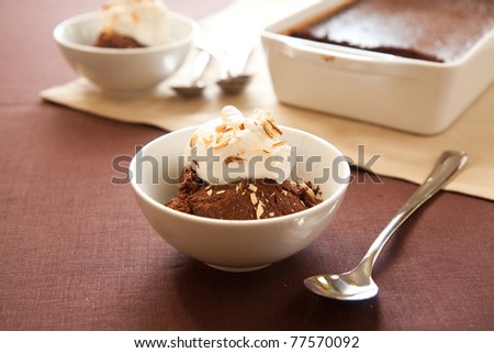 Italian dessert chocolate sformato topped with whipped cream and almonds
