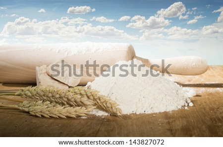 Rolling pin,flour and wheat ears. Cereal crops on the background