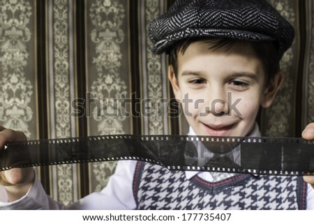 Child considered analog photographic film. Vintage clothes and background
