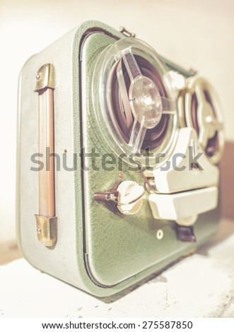 Old vintage green tape recorder on pink wall
