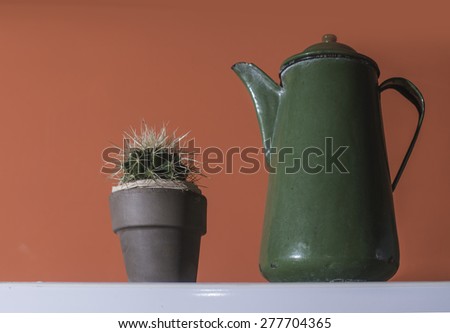 Green vintage kettle on red wall