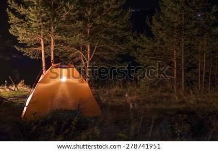 Orange tent in the forest at night