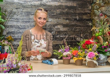girl counts the money in the store flowers. Focus on the model of the left