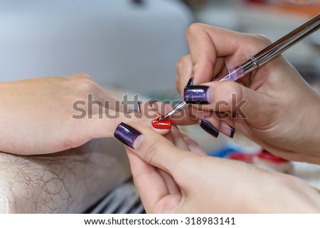 painting nails in nail salon, UV lap of quick dry nail polish manicure, focus on brush