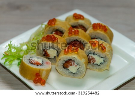 Close-up of a white plate with sushi set - Russian pancakes with caviar and strawberries , shallow depth of field,  focus on near-term