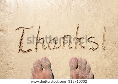 Conceptual thanks handwritten text in sand on a beach in an exotic island with feet for summer, ocean, sea, travel, vacation, tourism, tropical, coast, message, resort, paradise, sunny or water