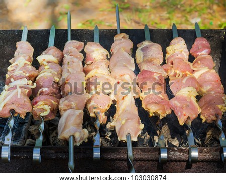 many roast meat pieces get on skewer. shish kebab cooking process