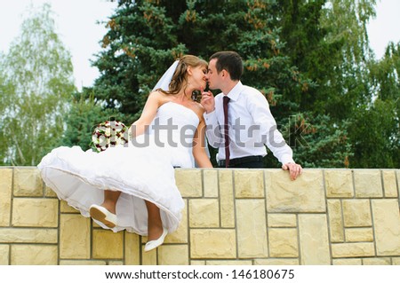 wedding couple kiss and dangle feet. Tenderness loving