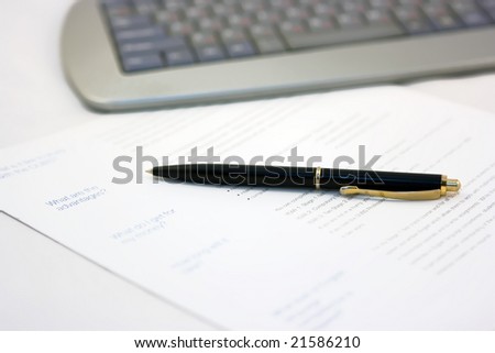 Paper, pen, and computer keyboard on the table