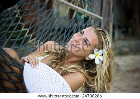 Happy girl with white hat sitting in hammock