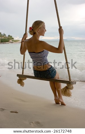 Girl on rope swings at the beach