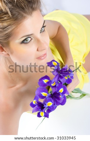 Beautiful blonde with gladiolus flowers in hands isolated on white
