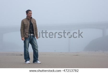 Man standing in fog and bridge silhouette on the background