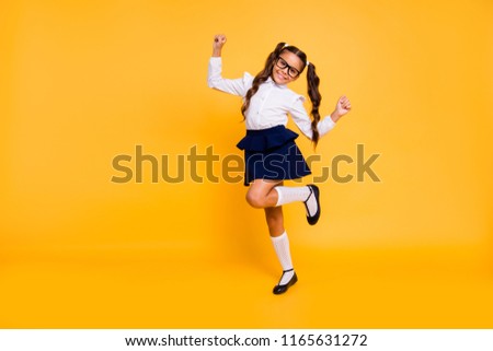 I'm happy because I'm going back to school! Full length, legs, body, size portrait of small girl isolated on bright yellow background stands on one leg raised her hands up Stock fotó © 