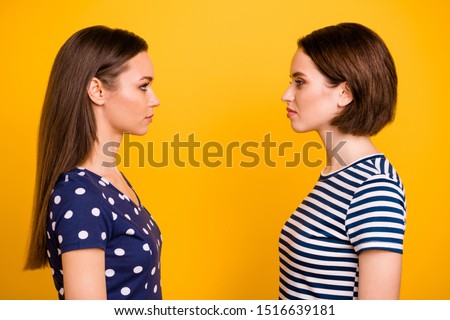 Profile photo of two amazing ladies standing opposite hate each other deciding who is better wear casual dotted and striped t-shirts isolated yellow background ストックフォト © 