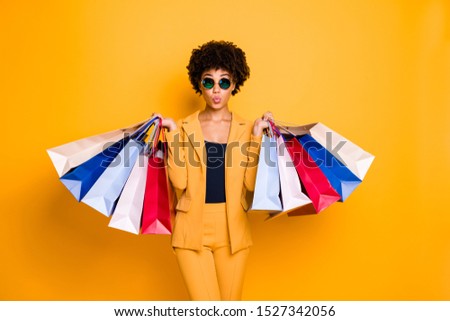 Portrait of funny funky brunette wavy hair afro american lady on leisure travel hold bags shopping purchase addicted person wear style sunglass outfit pants trousers isolated yellow color background ストックフォト © 