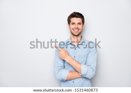 Portrait of positive cheerful guy promoter point index finger recommend ads select suggest adverts  wear casual style clothes isolated over grey color background Foto d'archivio © 