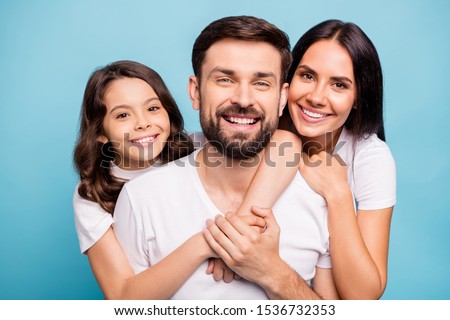 Close up photo of cheerful content three people with cute schoolkid hug lean shoulder cuddle piggyback enjoy weekends holidays wear white trendy t-shirt isolated over blue color background