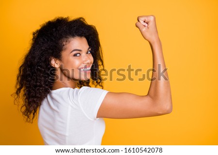 Close-up profile side view portrait of her she nice attractive lovely brunet cheerful wavy-haired girl showing strong muscles isolated over bright vivid shine vibrant yellow color background
