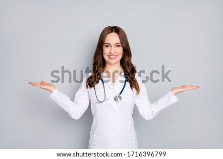 Portrait of her she nice attractive cheerful wavy-haired doc phonendoscope stethoscope holding copy space on palm advert isolated over grey pastel color background Stock foto © 