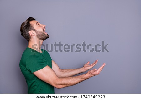 Profile photo of attractive amazed handsome guy good mood raise arms up side empty space waiting novelty product falling catch wear casual green t-shirt isolated grey color background Stock foto © 