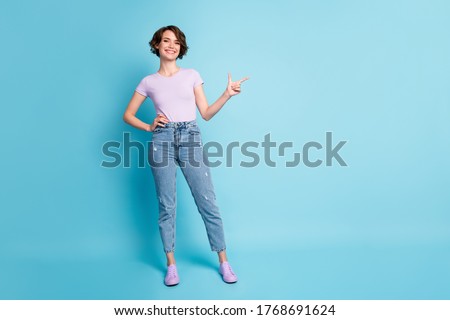 Full size photo of positive girl promoter point index finger copyspace indicate adverts promotion wear good look lilac outfit isolated over blue color background