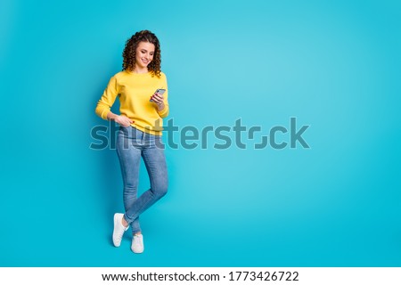 Full length body size view of her she nice attractive focused cheerful wavy-haired girl walking using device browsing media multimedia isolated over bright vivid shine vibrant blue color background