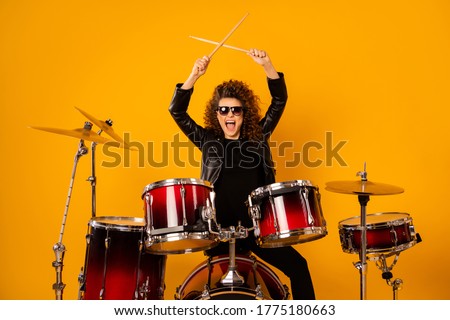 Photo of popular rocker redhair lady plays instruments beat raise hands drum sticks concert sound check repetition wear black leather outfit sun glasses isolated yellow background