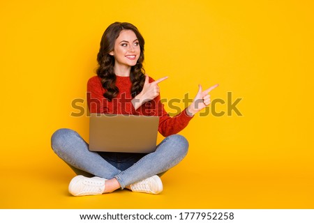 Portrait of her she nice attractive cheerful cheery wavy-haired girl sitting using laptop showing idea copy space advert isolated on bright vivid shine vibrant yellow color background