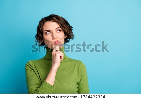 Portrait of minded interested girl touch finger chin look copyspace think thoughts decide decision wear green jumper isolated over blue color background Stockfoto © 