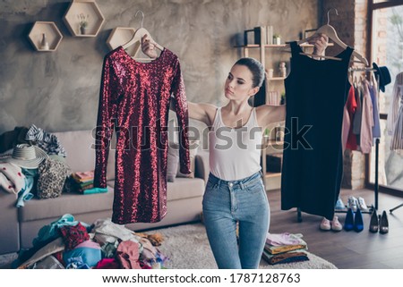 Portrait of her she nice attractive doubtful girl holding in hands hangers two new chic designer couture dress comparing preparing party wear in modern loft industrial interior apartment Stock foto © 