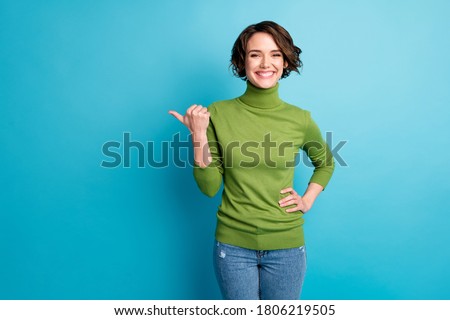 Portrait of cheerful lady direct thumb finger empty space demonstrate adverts wear casual clothes isolated blue color background