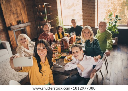 Photo of full family gathering eight people woman mother hold telephone make shoot selfie harmony peaceful day served dinner big table turkey generation in home evening living room indoors
