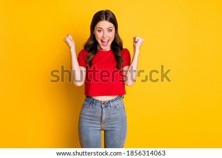 Photo of excited curly lady raise fists hands wear casual red t-shirt crop top isolated vibrant yellow color background Foto stock © 