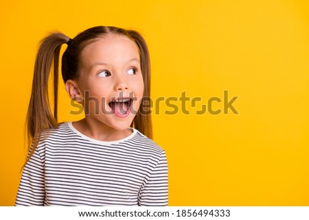 Photo of Portrait of happy excited amazed open mouth kid child girl look in copyspace isolated on yellow color background