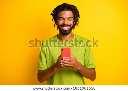 Photo of positive dark skin guy use cellphone read social media news isolated over bright ahine color background Stok fotoğraf © 