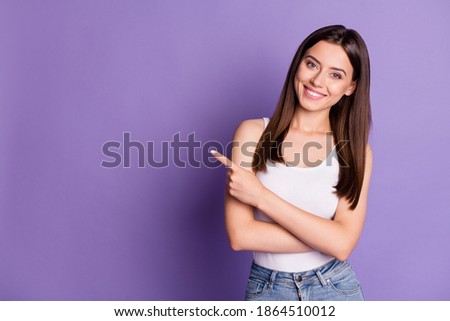 Photo of cute adorable young woman wear casual white outfit pointing empty space isolated violet color background