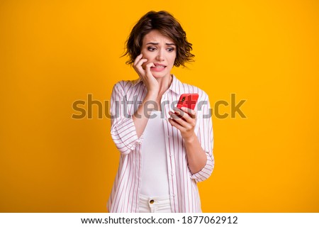 Photo of anxious frightened girl use smartphone feel fear about social media feedback comments bite fingers wear style stylish clothes isolated bright shine color background Stock foto © 