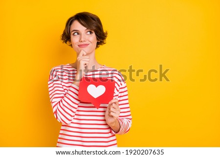 Photo of optimistic brunette lady hold like look empty space wear red shirt isolated on orange color background