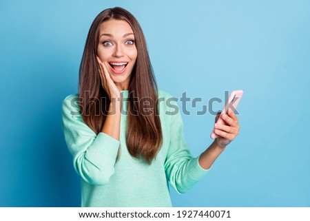 Portrait of lovely amazed cheerful brown-haired girl using device 5g app post like reaction isolated on bright blue color background
