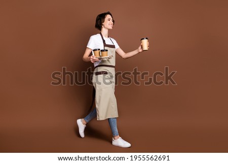 Full length body size view of lovely cheerful girl carrying bringing coffee time break isolated over brown color background 商業照片 © 