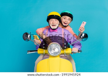 Photo of married old grey haired couple biker ride wear helmet hold phone isolated on blue color background