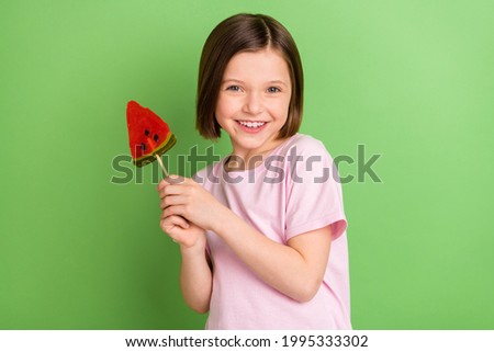 Foto Bild Kleines Mädchen hält eine Kiwi und eine Orange vor ihren Augen und lacht