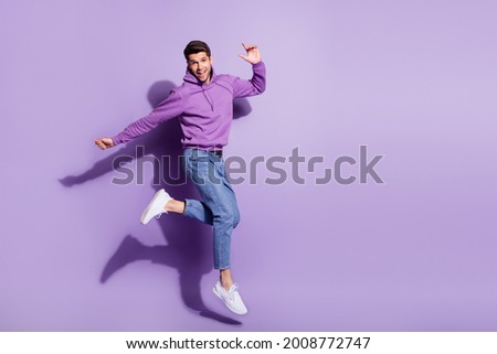 Full length body size view of attractive funny cheerful guy jumping having fun isolated over purple violet color background
