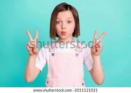 Photo of funny happy cheerful young girl send air kiss make v-signs isolated on pastel teal color background Stock fotó © 