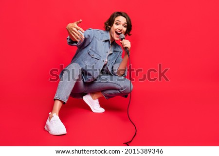 Full size photo of young woman happy positive smile singer rapper celebrity isolated over red color background