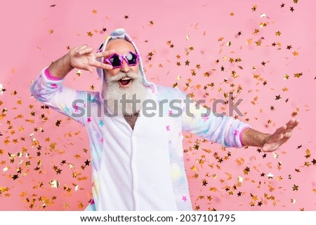 Photo of friendly pensioner man dance show v-sign confetti fall wear sunglass kigurumi isolated pink color background ストックフォト © 