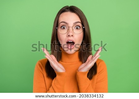 Portrait of attractive amazed girl wearing specs news reaction stupor stare eyes isolated over green color background Foto d'archivio © 