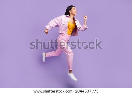 Full length profile photo of funny young brunette lady run wear jacket jeans sneakers isolated on violet background Photo stock © 